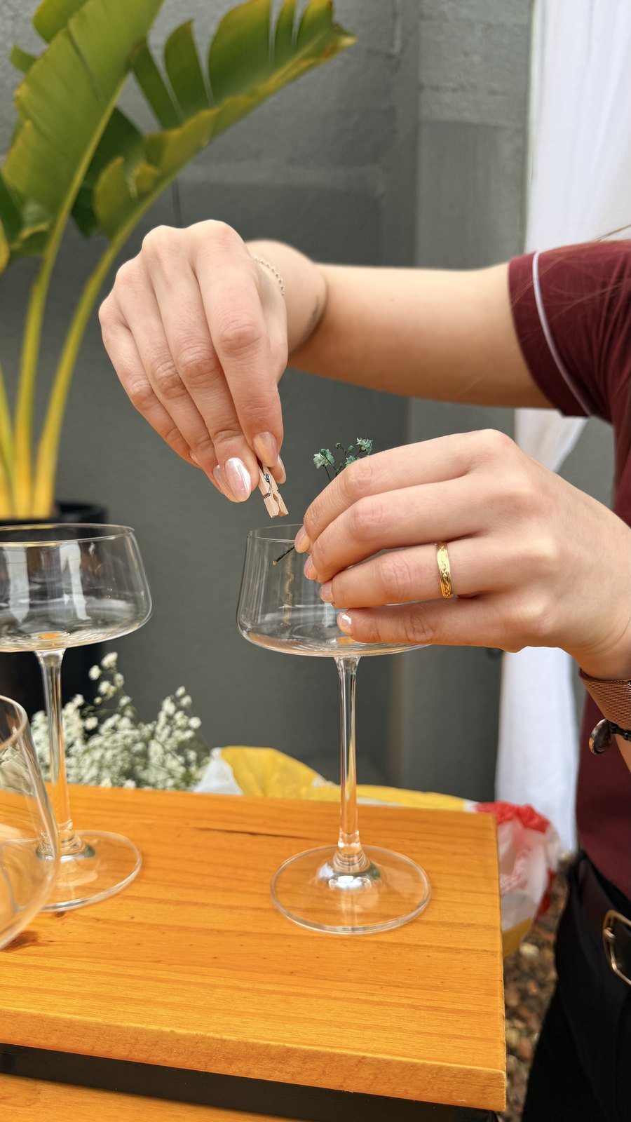 Mãos finalizando um drink com uma flor
